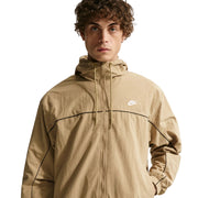 Man wearing a beige Nike jacket on a white background