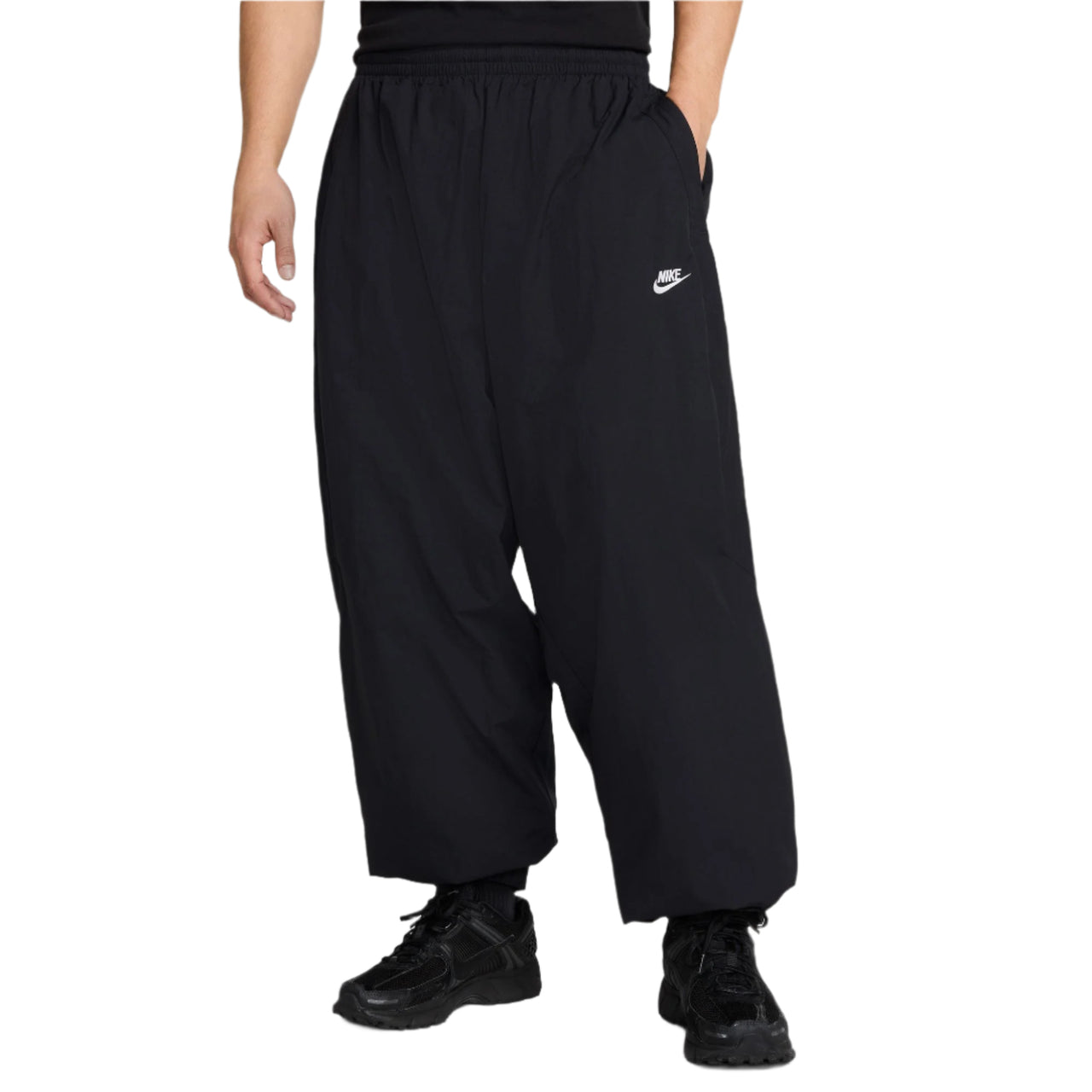 Person wearing black Nike pants on a white background