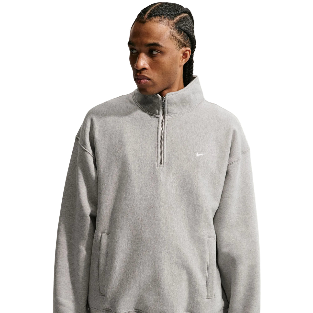 Person wearing a gray Nike half-zip sweatshirt on a light gray background