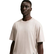 Man wearing a plain Nike beige t-shirt against a white background