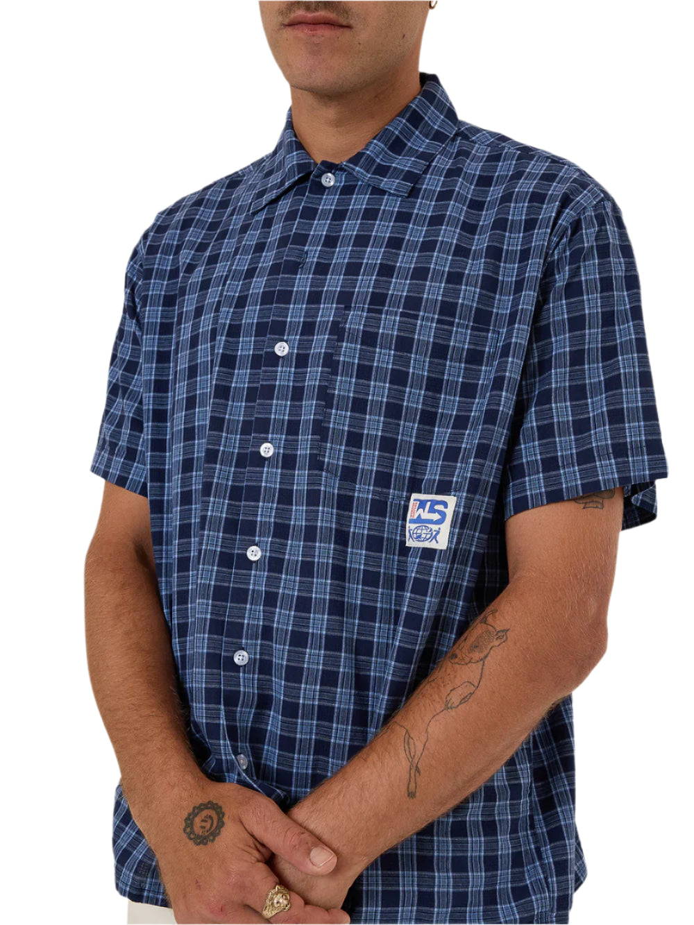 Person wearing a blue plaid shirt with a logo on a white background